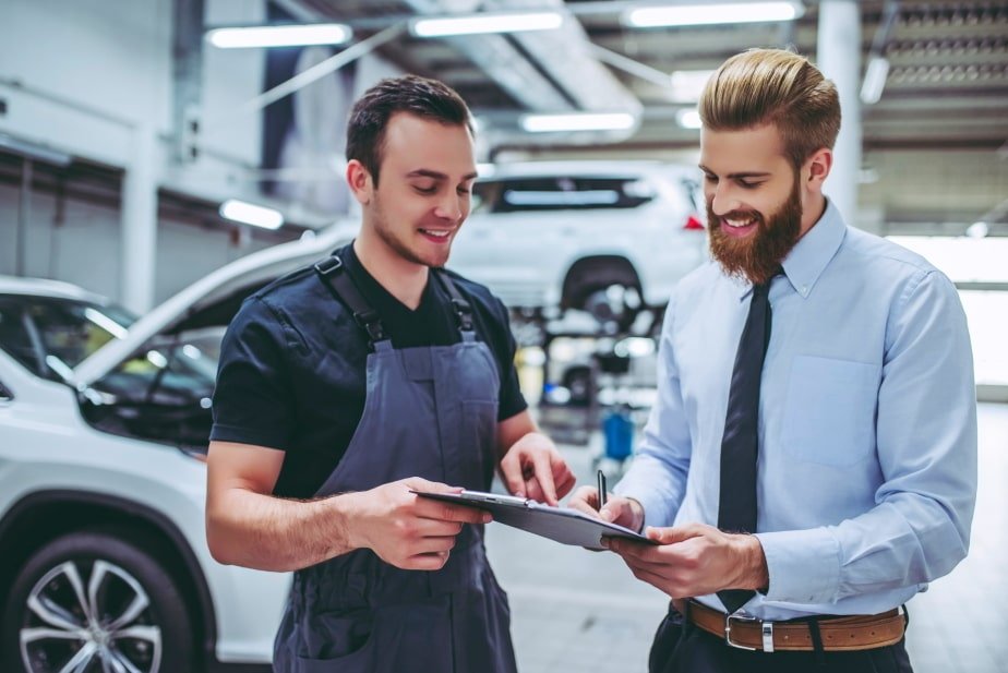 Professional car mechanic with the owner of the car